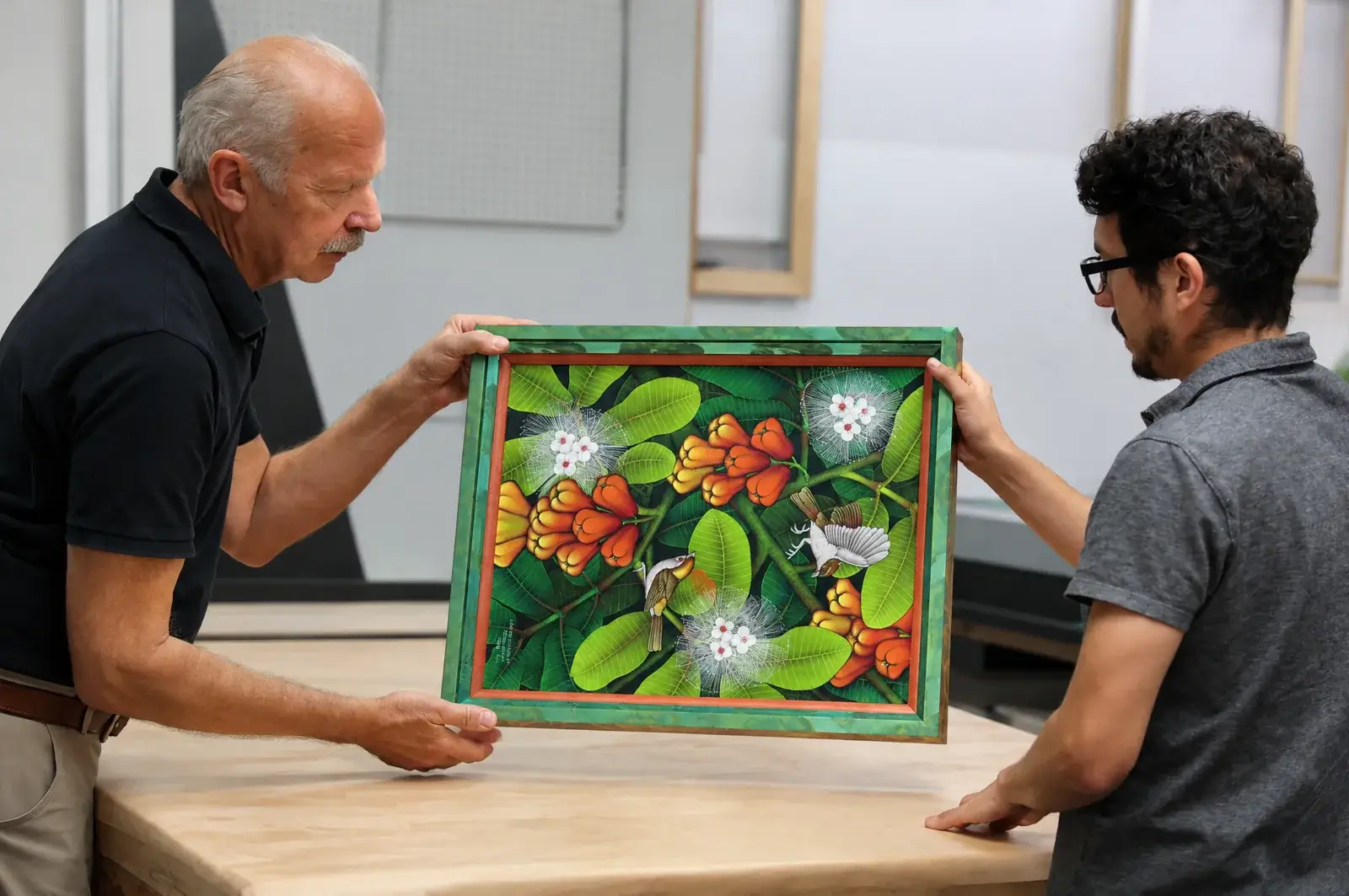 Two Masten framing professionals discussing original artwork in the studio