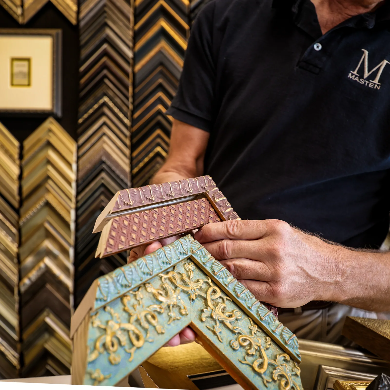 Hands comparing decorative custom frame moulding samples